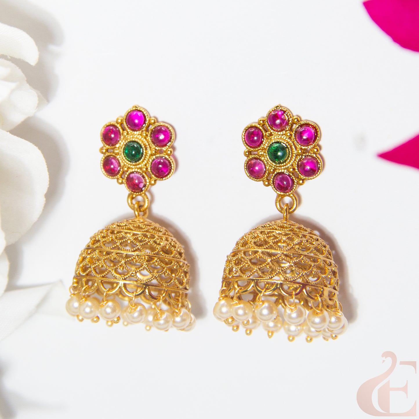 Gold earrings with colorful gemstones on a white background