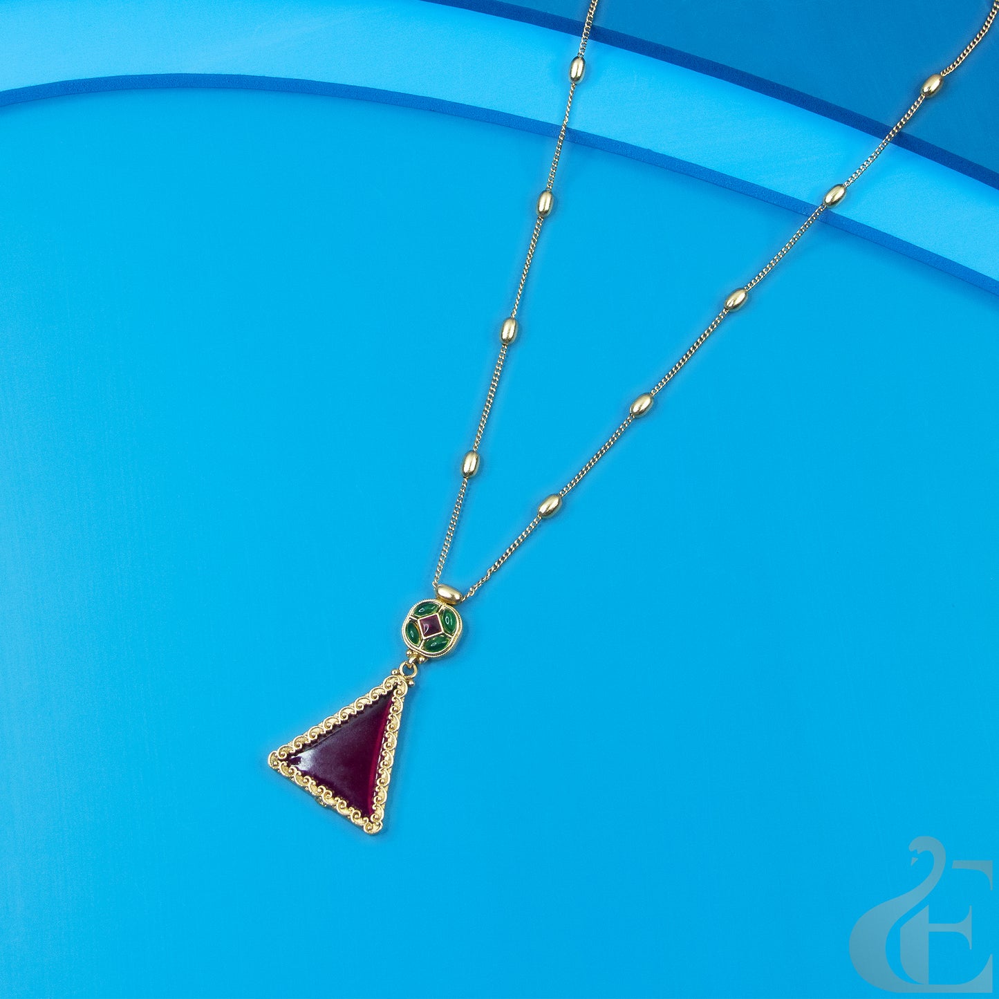 Top view of Triangle Pendant Long Chain Necklace & Earrings Ruby Green Stones