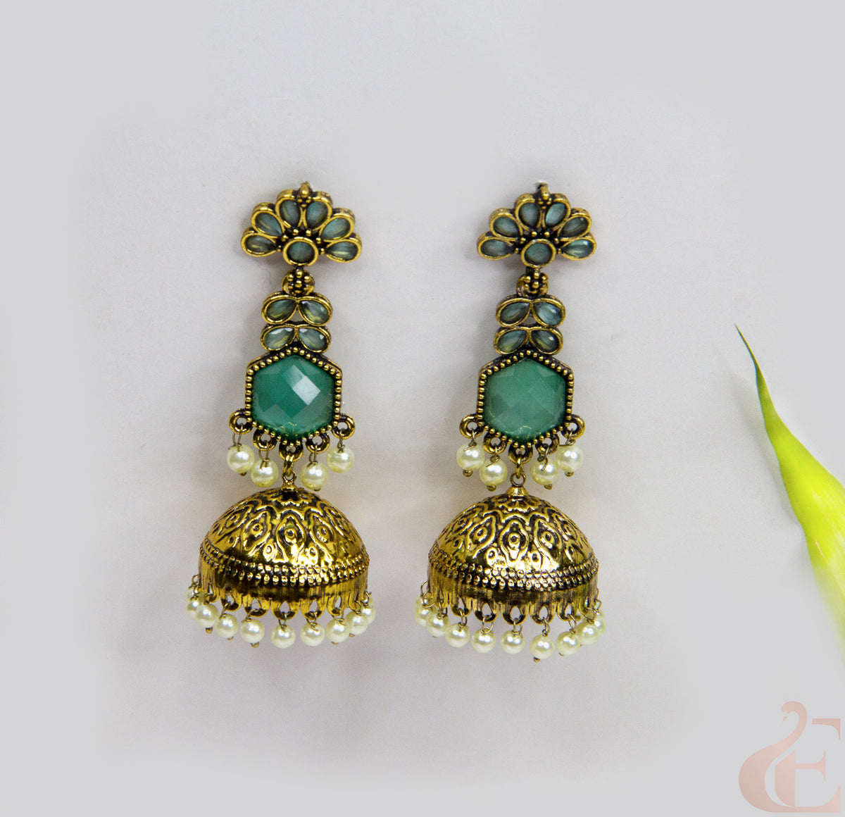 Pair of gold and turquoise earrings on a light gray background
