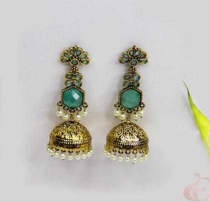 Pair of gold and turquoise earrings on a light gray background