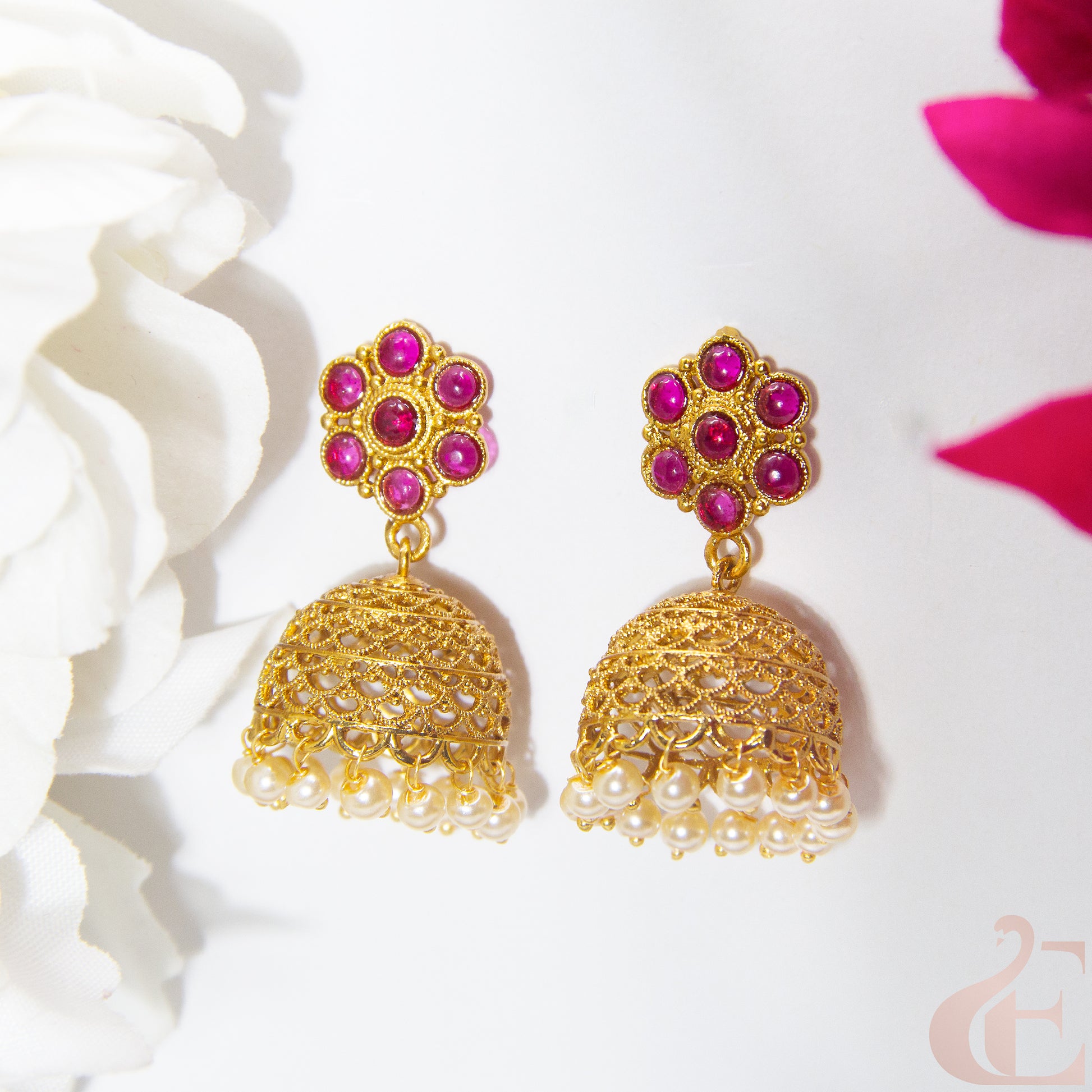 Gold earrings with RUBY gemstones on a white background