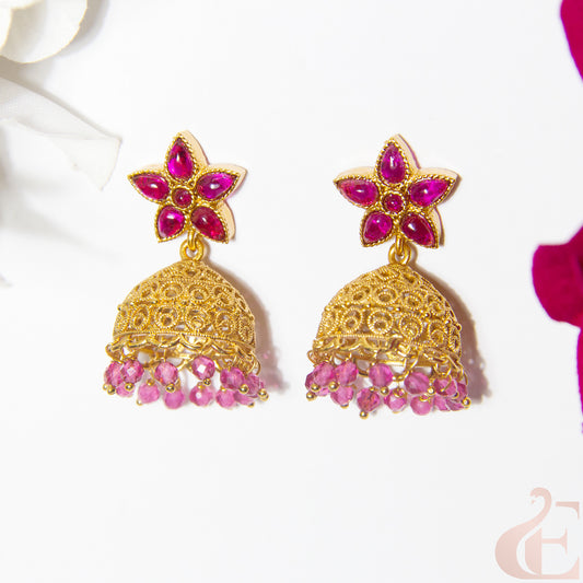 Gold and ruby earrings on a white background