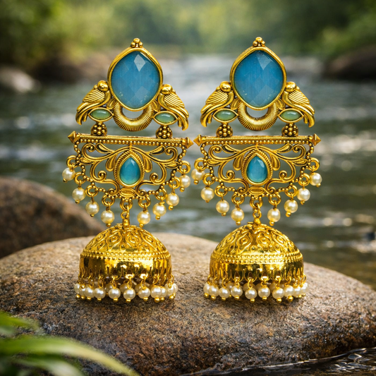 Gold and turquoise earrings on a rock with a natural background