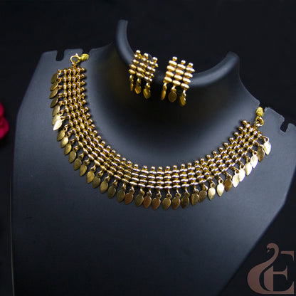 Gold-toned jewelry set displayed on a black mannequin bust, featuring a multi-strand leaf-shaped chain necklace and matching rectangular drop earrings, photographed against a dark background.