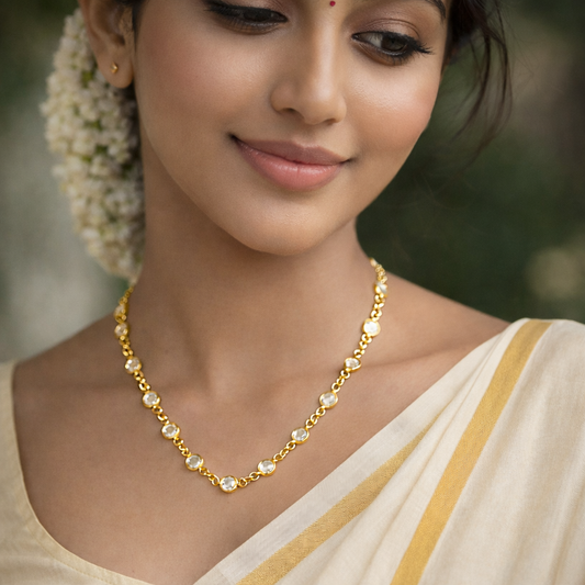 Woman wearing a gold necklace with a blurred background