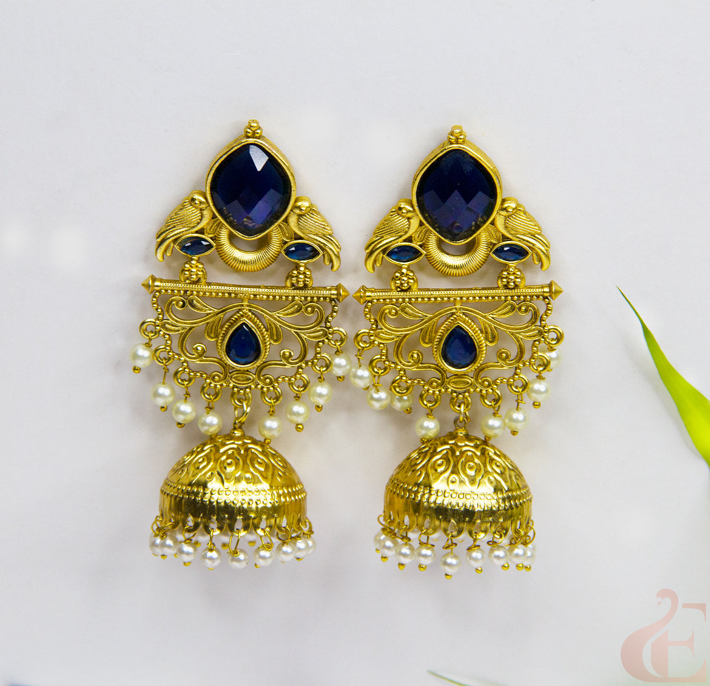 Gold and blue gemstone earrings on a white background