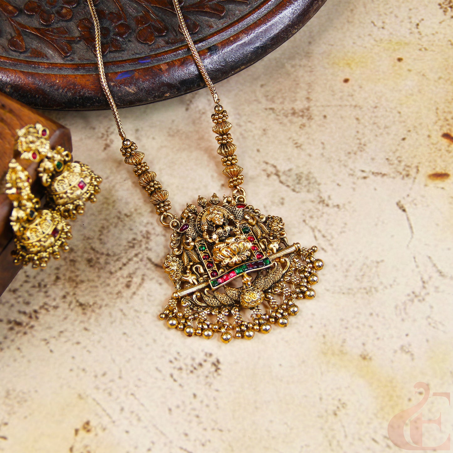 Gold necklace with intricate design on a textured surface