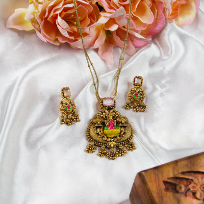 Gold necklace with floral pendant on a white fabric background