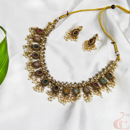 Ornate necklace with colorful stones on a white fabric background