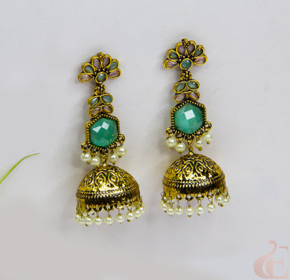 Pair of gold and turquoise earrings on a light gray background