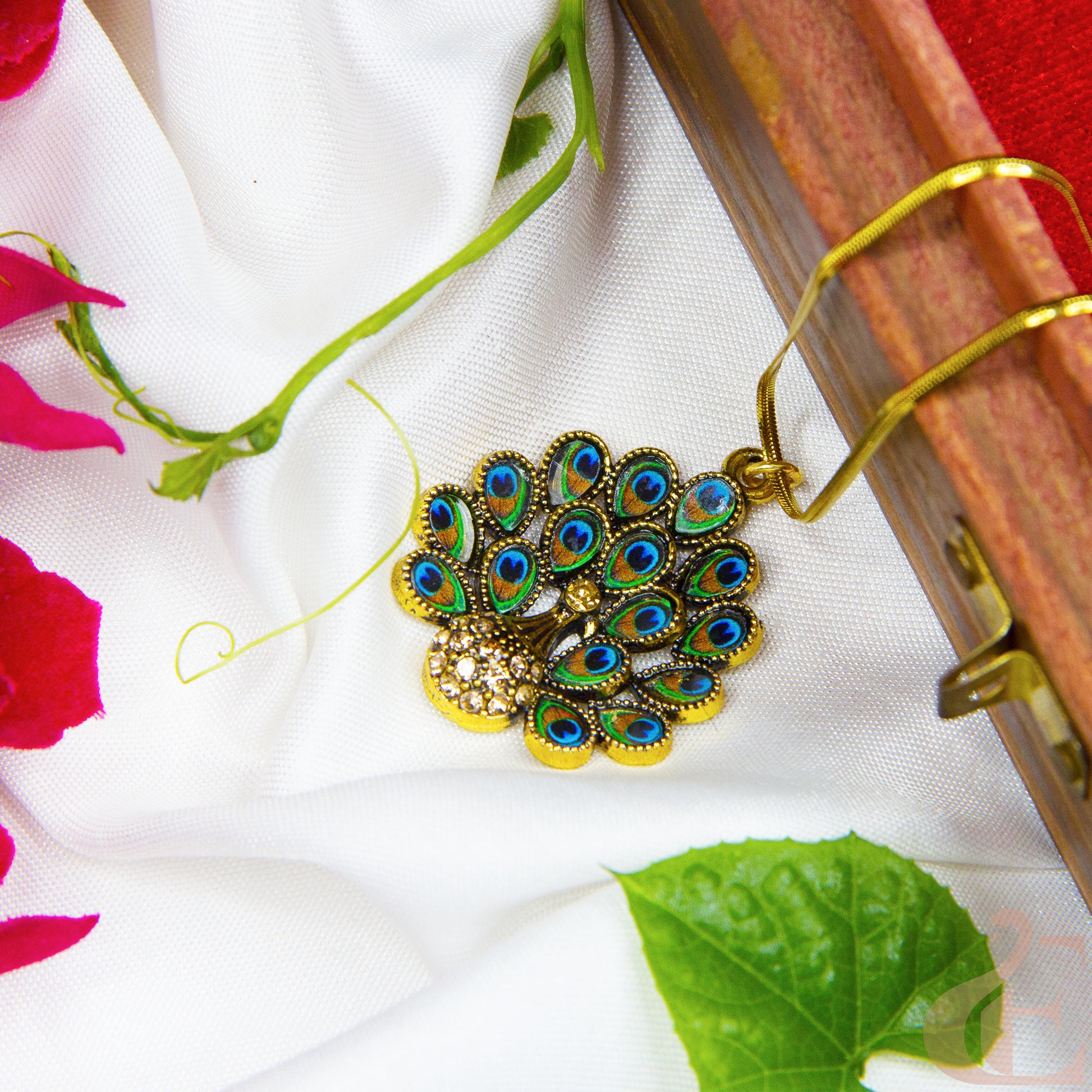 Decorative peacock feather pendant on a floral fabric background