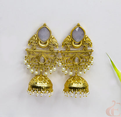 Gold earrings with intricate designs and pearl-like beads on a white background