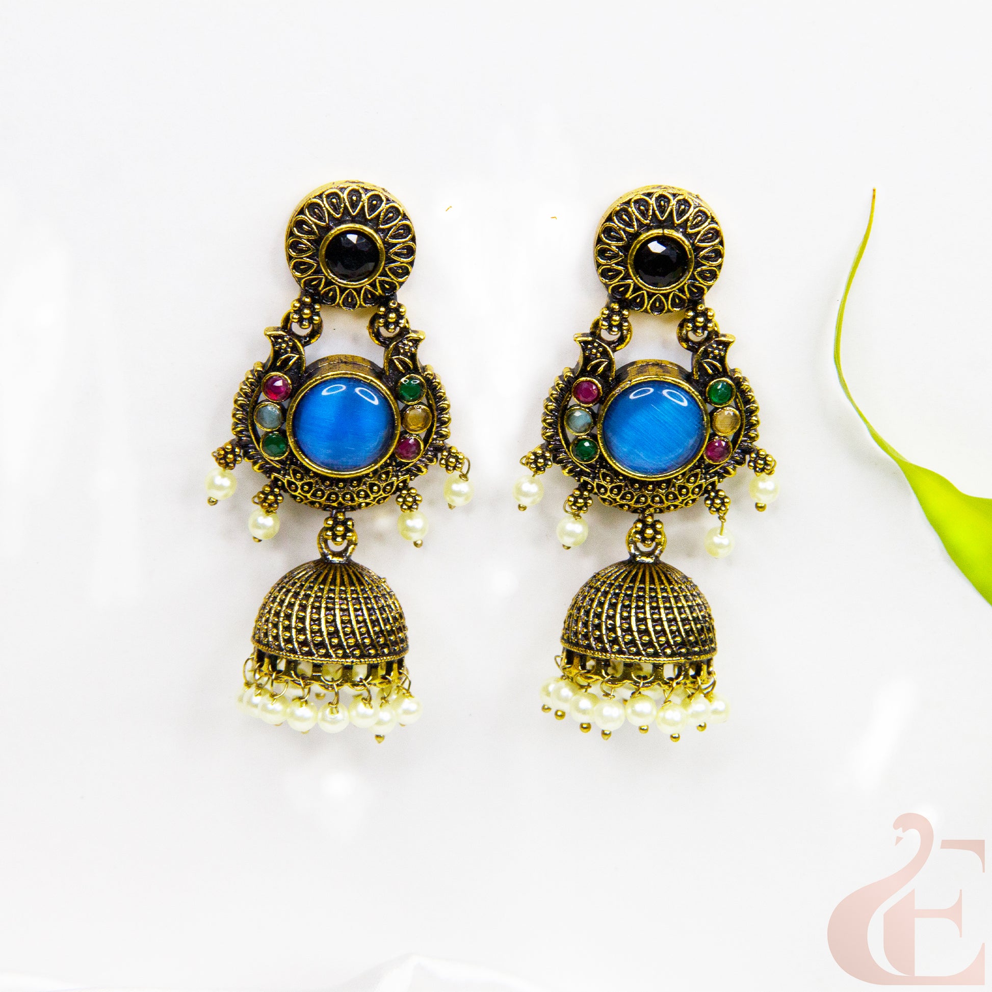 Ornate earrings with blue stones and gold accents on a white background