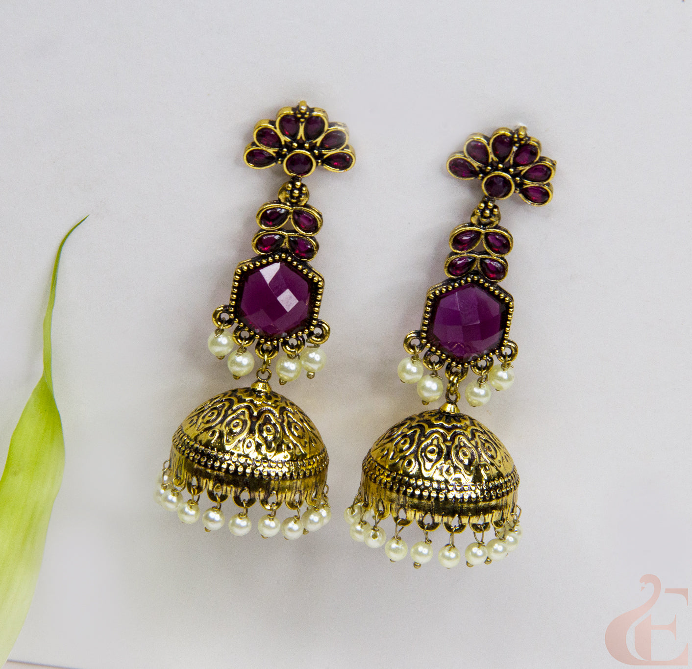 Pair of gold and purple earrings on a white background