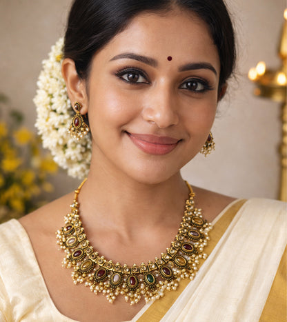 Woman wearing gold jewelry with a neutral background