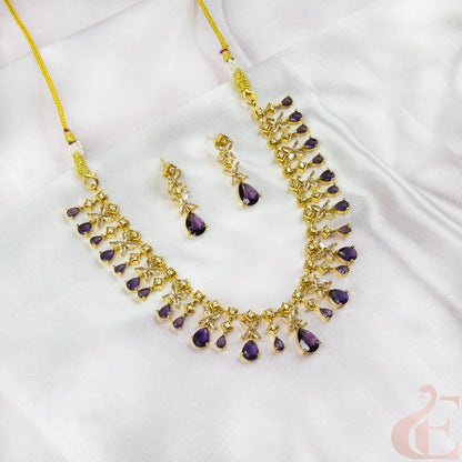 Gold necklace with purple stones on a white fabric background